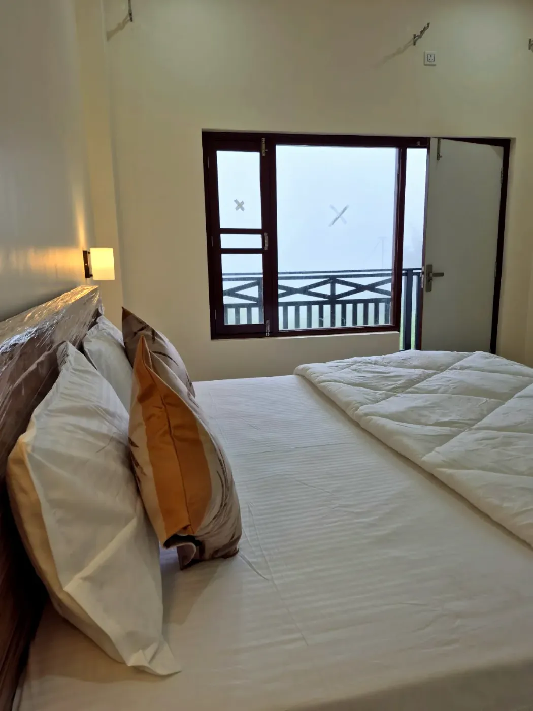 Bed beside a bright picture window over the treetops